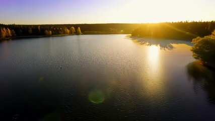 Poster - As the afternoon wears on the sun begins to slowly descend creating a soft glow over a tranquil lake its reflection shimmering on the waters surface.