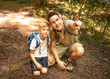 © kieferpix - Little boy and his father hiking together exploring nature wildlife. Father son spending quality family time together in the sunny summer forest. Daddy and his little son