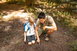 © kieferpix - Cute boy and his father hiking together and exploring learning about nature scouting. Little boy with his dad spending quality family time together in the sunny summer forest.