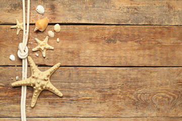 Wall Mural - Seashells and starfishes with rope on brown wooden background