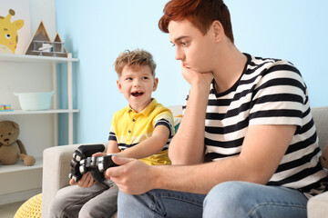 Wall Mural - Little boy with his father playing video game at home