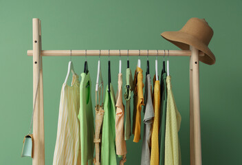 Female clothes hanging on rack against green background