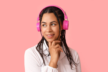 Poster - Young African-American woman listening to music on pink background