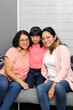 © Arlette - Three generations of brunette Latina women: grandmother, mom and daughter with glasses show their love and celebrate Mother's Day