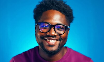 Wall Mural - Portrait of smiling african-american man in glasses, isolated on blue background