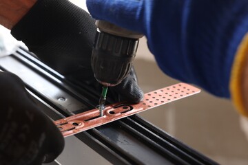 Sticker - Repairman installing new window with electric screwdriver indoors, closeup