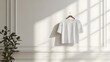 © IttikornP - White t-shirt mockup shown on a simple rack against a plain, bright wall, highlighting the clean lines
