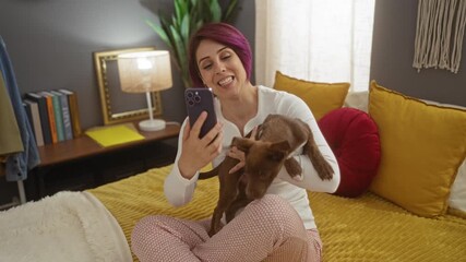 Poster - A young woman having a joyful video call in her bedroom while her playful dog jumps on her in a cozy indoor setting.