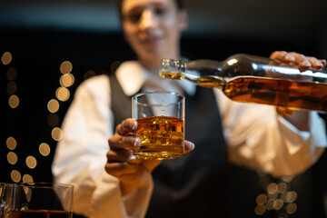 Wall Mural - Barman pouring whiskey whiskey glass beautiful night