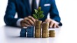 © Wasun - A businessman holding a plant growing from coins, representing financial growth and investment success, with elements of money, wealth, and economic growth