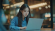 © hayley - Young Korean woman working on laptop in cozy café