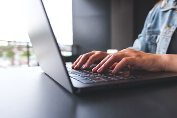 Closeup image of a woman hands working and typing on laptop computer keyboard