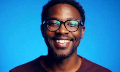 Poster - Portrait of smiling african-american man in glasses, isolated on blue background