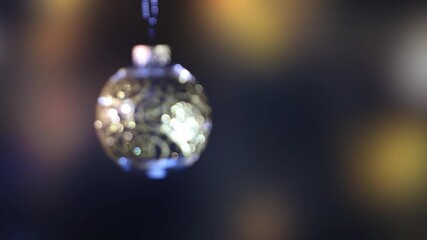 Wall Mural - glittering and swinging blurred christmas ball isolated on defocused festive background with copy space, motion design backdrop for december holidays with copy space