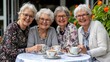 © naphat - Close-up Group of senior women having a tea party in a beautifully decorated garden, celebrating International Day of Older Persons, sharing laughter and stories, fostering friendship and joy.