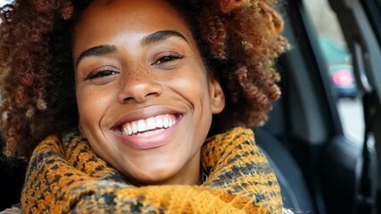 Wall Mural - A woman with curly hair and a yellow scarf is smiling. She is wearing a yellow scarf and has a smile on her face