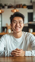Poster - A man with glasses is smiling and sitting at a table