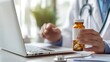 © inthasone - Close-up of the doctor's hand holding a bottle of pills near a laptop computer and a stethoscope lying on a clipboard medical documents on a desk in a clinic office. prescribe concept.
