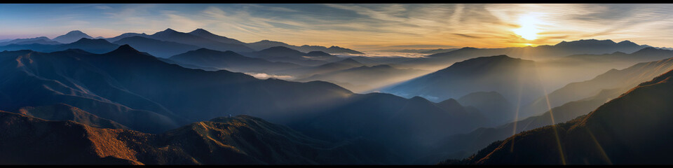 Wall Mural - the mountains are covered in a blanket of fog and the sun is setting behind them