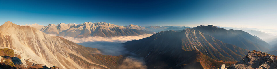 Wall Mural - a panoramic view of a mountain range with a foggy mist covering the peaks