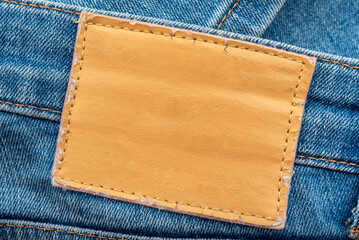 empty worn leather patch on blue jeans. empty space for writing. blank leather jeans label