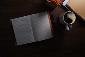 Wall Mural - Flat lay notebook, coffee cup and potted plant on wood office desk.