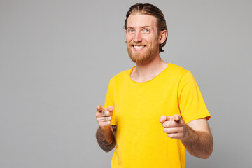 Wall Mural - Young confident leader Caucasian man he wear yellow t-shirt casual clothes point index finger camera on you motivating encourage isolated on plain grey background studio portrait. Lifestyle concept.