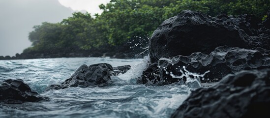 Wall Mural - Vacation themed wallpaper depicting a serene seacoast with dark grey sea rocks adorned with lush greenery surrounded by waves with splashes of water including a copy space image