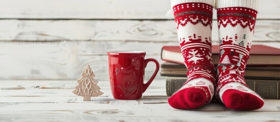 Aufkleber - Festive Christmas display red cup cozy winter socks with holiday design on books set against white wood background with copy space image