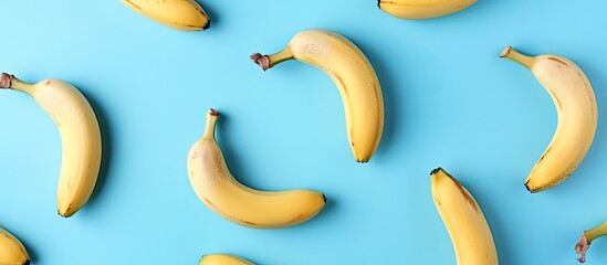 Poster - Top view of a healthy and simple raw food concept with a banana pattern on a blue background in a flat lay style shot with copy space image