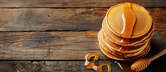 Sticker - Wooden table with pancakes drizzled in honey featuring ample copy space image