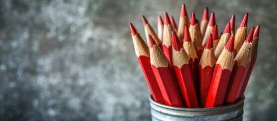 Poster - Red sharp wooden pencils placed in a metal tin on a gray background with focus on the pencils ideal for a copy space image