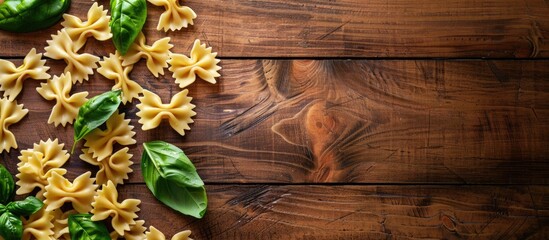 Canvas Print - A pleasing top view of farfalle and fresh basil leaves on a wooden table with copy space for text