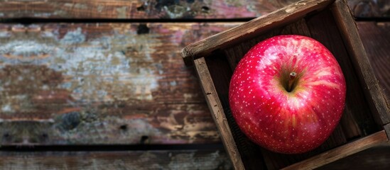 Aufkleber - A lovely pink apple lies in the box on a wooden floor representing a healthy fruit option with a clear background for a copy space image