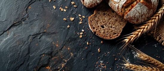 Poster - Healthy lifestyle concept with brown rye bread on a dark stone backdrop with copy space image