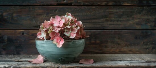Aufkleber - A vintage autumn decoration featuring a half dried slightly faded pink hydrangea flower placed in an old green soup bowl against a dark wooden backdrop copy space image