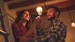 © The Little Hut - Happy family couple changing a LED lightbulb at home Joyful young man and woman standing on a step ladder and changing an energysaving light bulb in a white lamp on the ceiling : Generative AI