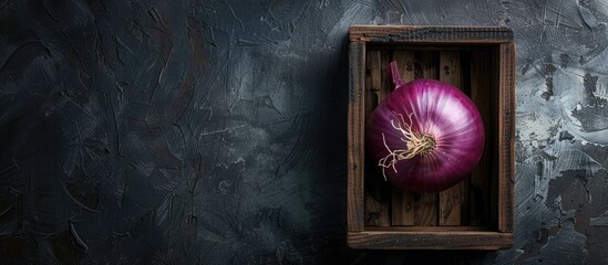Poster - Top view of a purple onion in a wooden box on a black background with ample space for additional images