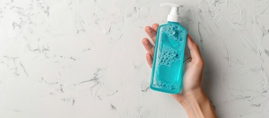 Poster - Hand holding a bottle of shower gel on a white background with copy space image