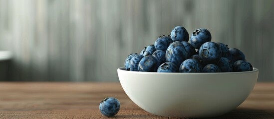 Poster - Blueberries displayed in a clean bowl on a wooden surface offering a spacious copy space image