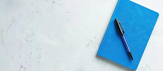 Poster - blue notebook and pen seen from above on a white background suitable for school or office wallpapers