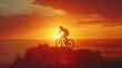 © Oskar - Cyclist on a hilltop at sunset with a bright orange sky and ocean in the background
