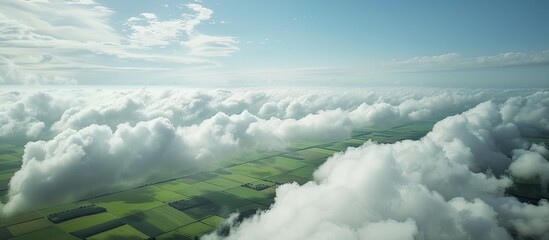 An aerial photograph capturing the sky white clouds and expansive farmland below providing a serene copy space image