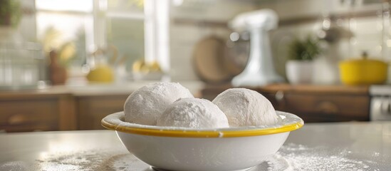 Poster - A close up of two white bread dough balls covered in flour inside a white bowl with yellow trim on a bakery kitchen counter with copy space image available