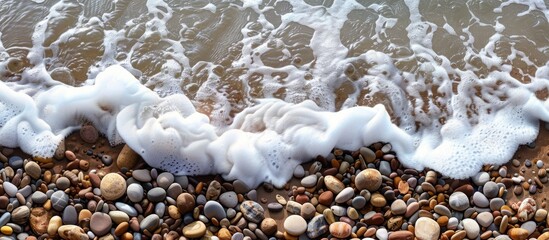 Poster - Coastal sea wave foaming near pebble beach with serene copy space image