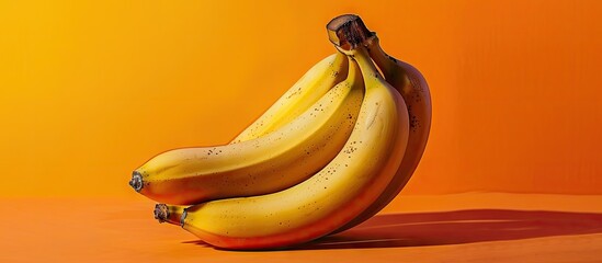 Poster - Vibrant yellow bananas displayed against an orange backdrop providing a striking copy space image