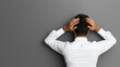 © Oranuch - A man in a white shirt holds his head in frustration against a gray wall, symbolizing stress, anxiety, and overwhelming emotions.