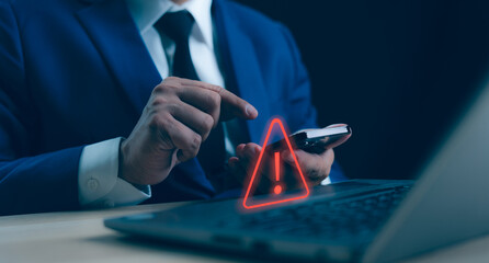 A Businessman developer working and using laptop computer with triangle caution warning sign for notification error and maintenance concept, network security, computer virus detected data protection.