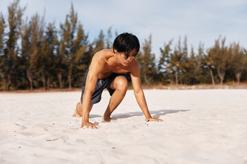 Wall Mural - Active Lifestyle: Muscular Asian Athlete Enjoying Cardio Workout on a Sandy Beach at Sunset