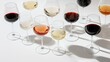 © RaptorWoman - Elegant display of red, white, and ros? wine glasses casting shadows on a clean white background.